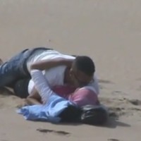 Spying Moroccan Couple Touching on Beach
